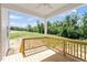Wooden back porch with a ceiling fan featuring a picturesque view of the lush backyard and surroundings at 65 Cordoba Dr, Franklinton, NC 27525
