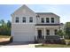 Charming two-story home with stone accents, covered porch, attached garage, and manicured lawn in a suburban setting at 65 Cordoba Dr, Franklinton, NC 27525
