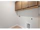 Functional laundry room with neutral tones, upper cabinets, and tile flooring at 65 Cordoba Dr, Franklinton, NC 27525
