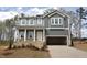 A modern two-story home featuring a two-car garage, stone accents, and gray siding at 70 Cordoba Dr, Franklinton, NC 27525