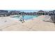 A large community pool with a handicap lift, seating, and a covered gathering area surrounded by landscaping at 76 Commons Cir, Clayton, NC 27520