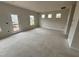 Open-concept living room area with door to the backyard and several windows allowing for lots of natural light at 76 Commons Cir, Clayton, NC 27520