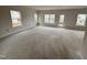 Spacious living room featuring multiple windows that let in ample natural light and access to an outdoor patio at 76 Commons Cir, Clayton, NC 27520