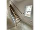 View of a home's staircase featuring wood railing, black balusters, and natural light from a window at 76 Commons Cir, Clayton, NC 27520