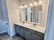 Bright bathroom featuring double sinks, stylish cabinetry, and sleek mirrors at 76 Commons Cir, Clayton, NC 27520