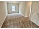 Spacious bedroom with neutral-colored walls, carpet, and a large window at 76 Commons Cir, Clayton, NC 27520