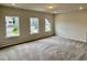 Bright bedroom with plush carpet, three windows, and neutral-colored walls at 76 Commons Cir, Clayton, NC 27520