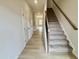 Bright entryway with wood-look flooring and carpeted stairs at 76 Commons Cir, Clayton, NC 27520