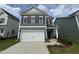 Charming two-story home featuring gray siding, brown shutters, a two-car garage, and a well-manicured front lawn at 76 Commons Cir, Clayton, NC 27520