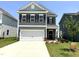 Charming two-story home with a two-car garage, well-maintained landscaping, and a welcoming front porch at 76 Commons Cir, Clayton, NC 27520