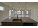 Kitchen island highlighting the granite countertop with view of the bright, open-concept living area beyond at 76 Commons Cir, Clayton, NC 27520
