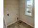 Clean laundry room features tile flooring, window, and washer/dryer hookups at 76 Commons Cir, Clayton, NC 27520