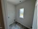 Functional laundry room with a bright window, washer/dryer connections, and vinyl flooring at 76 Commons Cir, Clayton, NC 27520