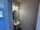 Cozy powder room featuring a pedestal sink with oval mirror and stylish lighting fixture at 76 Commons Cir, Clayton, NC 27520