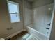 Clean bathroom features a shower-tub combo with a bright window and modern fixtures at 765 Portland Rose Dr, Knightdale, NC 27545