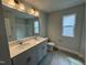 Bright bathroom featuring a double sink vanity, quartz countertop, and plank floors at 765 Portland Rose Dr, Knightdale, NC 27545