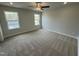 Bright bedroom with neutral carpet, paint, ceiling fan, and large windows for natural light at 765 Portland Rose Dr, Knightdale, NC 27545