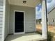 A modern front door with black hardware is framed by white columns and brick accents at 765 Portland Rose Dr, Knightdale, NC 27545