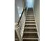 Carpeted staircase with white painted risers and dark stained steps and railing at 765 Portland Rose Dr, Knightdale, NC 27545