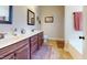 Well-lit bathroom with double sink, stylish brown cabinetry, and decorative wall art at 79 Hillgrove Dr, Willow Springs, NC 27592