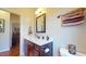 Bright bathroom with modern sink, framed mirror, and a view into the hallway at 79 Hillgrove Dr, Willow Springs, NC 27592