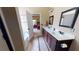 Bright bathroom featuring double sinks, a framed mirror, and a view into the bedroom at 79 Hillgrove Dr, Willow Springs, NC 27592