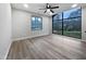 Bright bedroom with modern ceiling fan, wood floors, and large windows providing natural light at 8125 Park Side Dr, Raleigh, NC 27612