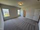Bedroom featuring plush carpeting, two windows, and a closet with a door at 84 Commons Cir, Clayton, NC 27520