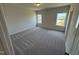 Bedroom featuring plush carpeting and two windows for natural light at 84 Commons Cir, Clayton, NC 27520