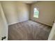 Cozy bedroom featuring neutral walls, plush carpeting, and a window with a view at 84 Commons Cir, Clayton, NC 27520