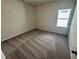 Comfortable bedroom featuring neutral walls, plush carpeting, and a window at 84 Commons Cir, Clayton, NC 27520