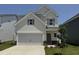 Charming two-story home with a two-car garage, stone accents, and a well-manicured lawn at 84 Commons Cir, Clayton, NC 27520