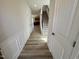 Inviting hallway featuring wood-look flooring and stairs leading to the upper level at 84 Commons Cir, Clayton, NC 27520