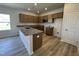 Kitchen with a large island, granite countertops, wood cabinets, modern appliances, and wood grain flooring at 84 Commons Cir, Clayton, NC 27520