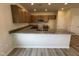 Kitchen island with granite countertops, wood cabinets, sink, modern appliances, and wood grain flooring at 84 Commons Cir, Clayton, NC 27520