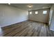 Bright, empty living room with recessed lights, modern light wood flooring and three small windows on the wall at 84 Commons Cir, Clayton, NC 27520