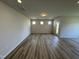 Bright, empty living room with recessed lights, modern light wood flooring, and a door to the backyard at 84 Commons Cir, Clayton, NC 27520