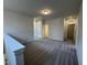 Upstairs loft space with carpeted floor, neutral paint and natural light. There are three doors in the space at 84 Commons Cir, Clayton, NC 27520