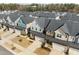 An aerial view of a new neighborhood showcases modern townhomes with neatly manicured lawns and community spaces at 8410 Zinc Autumn Path, Raleigh, NC 27615