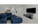 Finished basement area with plush blue sectional, entertainment center, and neutral decor at 8410 Zinc Autumn Path, Raleigh, NC 27615