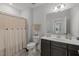 Clean bathroom with a vanity, large mirror, and a shower-tub combination with a curtain at 8410 Zinc Autumn Path, Raleigh, NC 27615