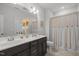Bathroom boasts dual sinks, a vanity with white countertops, and a shower behind an elegant curtain at 8410 Zinc Autumn Path, Raleigh, NC 27615
