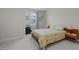 Comfortable bedroom featuring a patterned quilt, window view, soft carpet, and warm lighting at 8410 Zinc Autumn Path, Raleigh, NC 27615