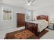 This bedroom features a ceiling fan, two windows, and classic dark wood furniture set on top of an area rug at 8410 Zinc Autumn Path, Raleigh, NC 27615