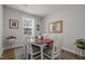 Cozy dining room with a large window providing natural light and classic decor with a mirror at 8410 Zinc Autumn Path, Raleigh, NC 27615