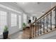Inviting foyer featuring hardwood floors, staircase with iron spindles, and plenty of natural light at 8410 Zinc Autumn Path, Raleigh, NC 27615