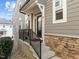 Inviting townhome entrance with stone accents, a sleek black door, and well-maintained landscaping at 8410 Zinc Autumn Path, Raleigh, NC 27615
