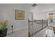 Upstairs hallway features decorative iron railing, neutral carpeting, and elegant artwork at 8410 Zinc Autumn Path, Raleigh, NC 27615