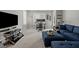 Spacious living room featuring an ultramodern TV stand, dual-monitor desk setup, and a comfortable navy sofa at 8410 Zinc Autumn Path, Raleigh, NC 27615