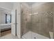 Stylish tiled shower with a glass door, modern fixtures, and open access to the main bedroom at 8410 Zinc Autumn Path, Raleigh, NC 27615